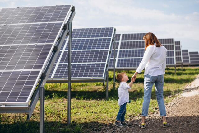Mother with her little son by solar panels